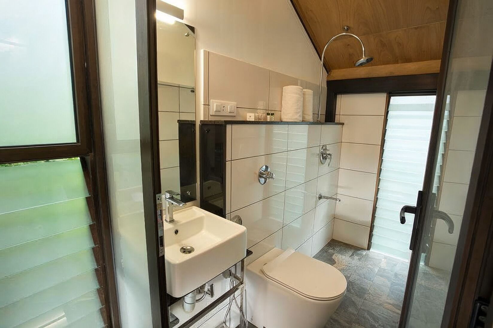 Un baño moderno con lavamanos, inodoro y ducha.