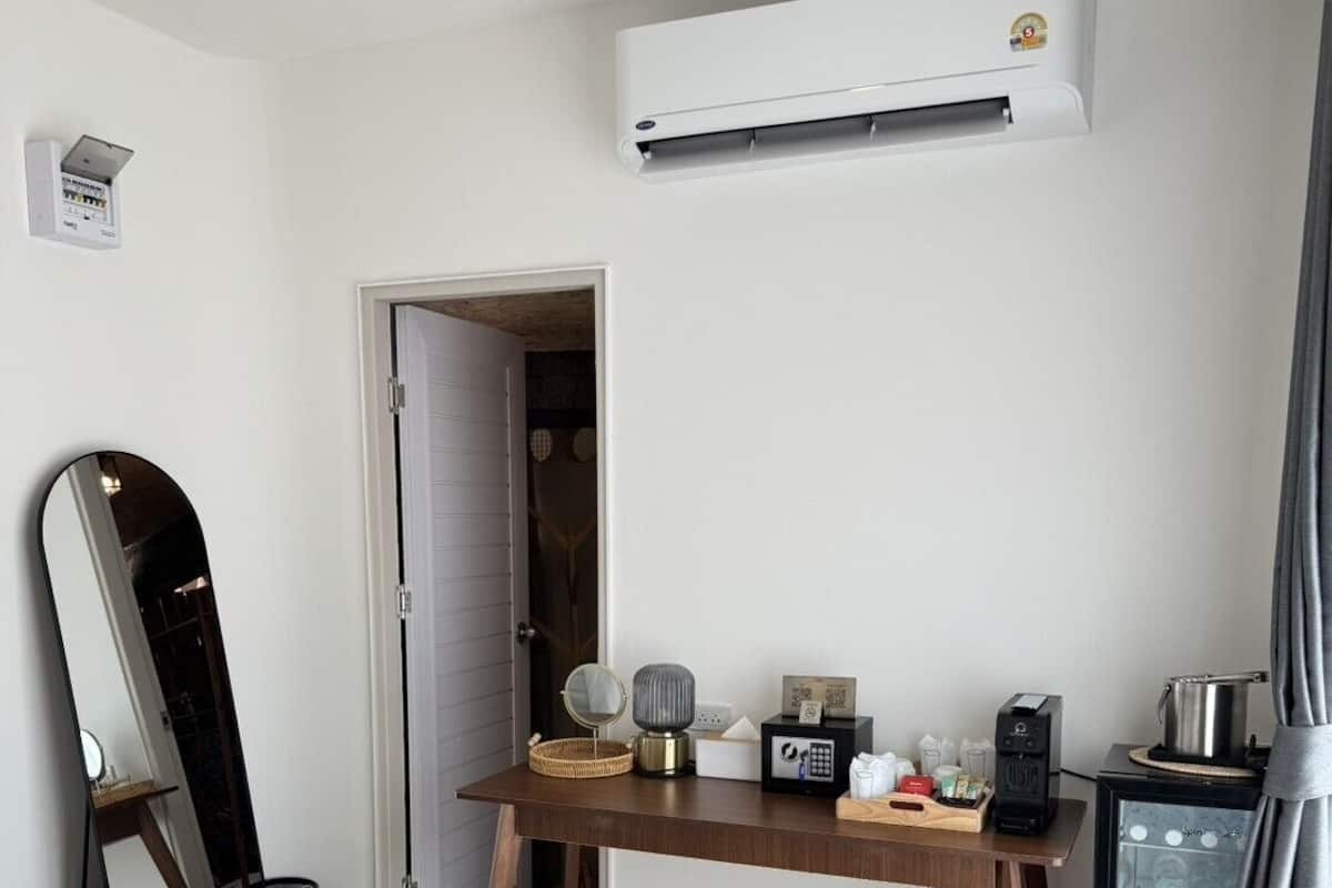 Une chambre d’hôtel équipée d’un lit, d’un bureau avec une machine à café, d’un miroir et d’un mini-bar.