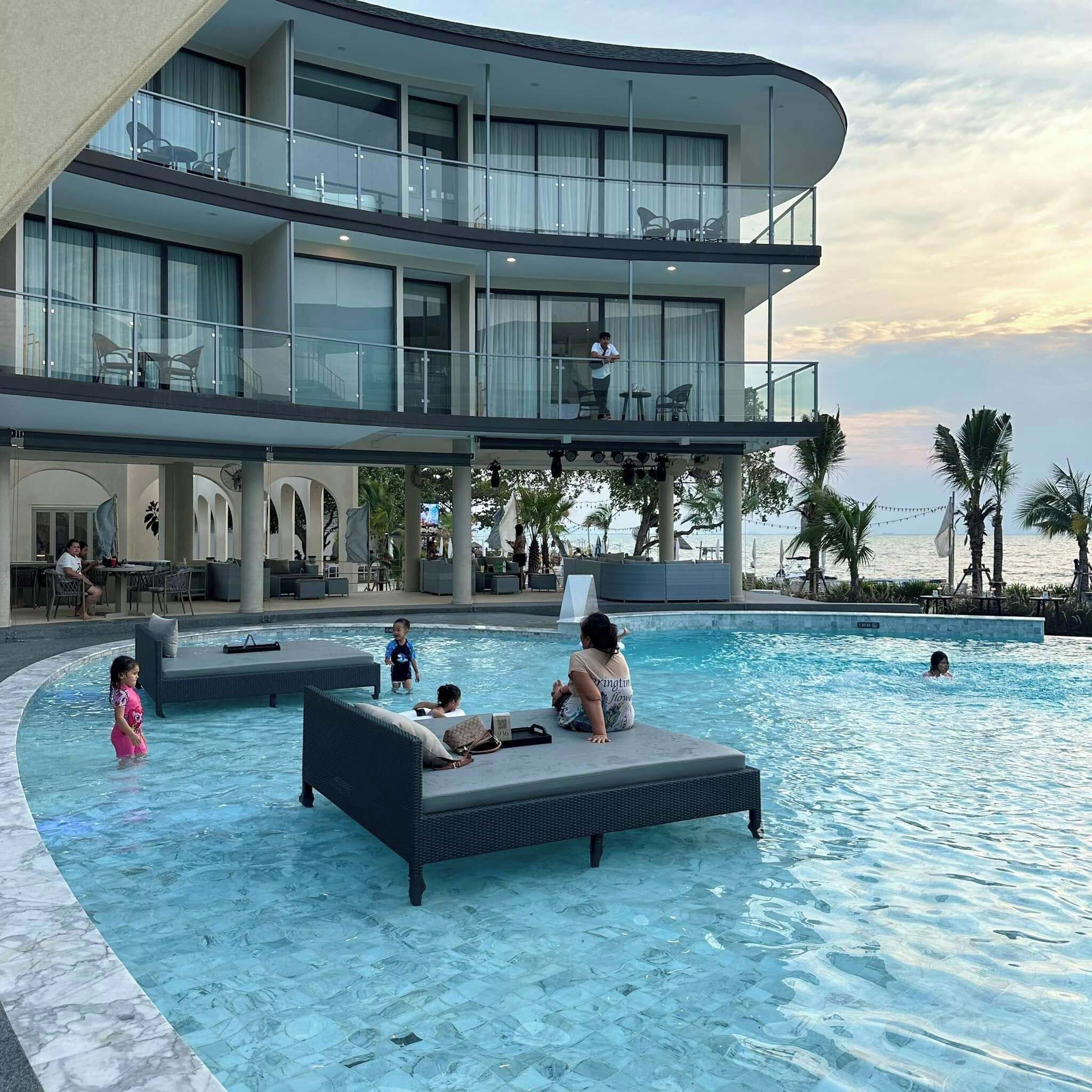 Een buitenzwembad, ligstoelen bij het zwembad