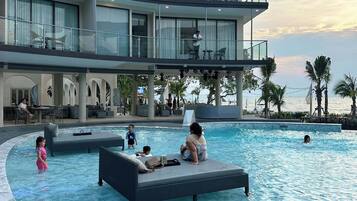 Een buitenzwembad, ligstoelen bij het zwembad