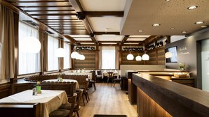 A restaurant interior with wooden paneling, pendant lighting, and a bar area. - Eisenbocks Strasser Hof (Straß im Straßertale)