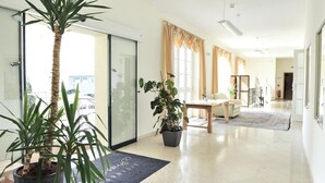 A spacious living area with a large potted plant, a sofa, and a coffee table. - Eisenbocks Strasser Hof (Straß im Straßertale)