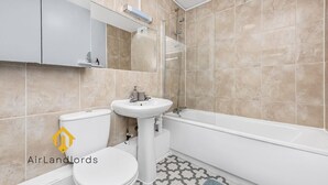 A modern bathroom with a toilet, sink, and bathtub. - Exclusive 4 bedroom apartment in Russell Square (Greater London)