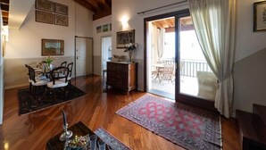 A spacious living area with wooden flooring, a dining set, a fireplace, and a view to an outdoor balcony. - ROMANTIC LAKE VIEW HOUSE (Sulzano)