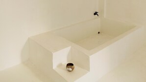 A minimalist bathroom with a white sink, a faucet, and a small basin. - The Hidden Home (Patong)