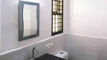 Ein Badezimmer mit Waschbecken, Spiegel und Toilette.