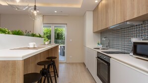 A modern kitchen with a central island, a built-in oven, and a microwave. - Vila Oleander - Malinska by Villas Guide (Dobrinj)