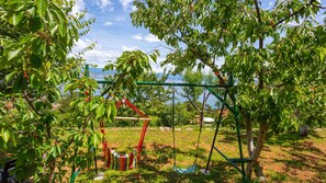 Une balançoire dans un parc, avec des arbres et une vue sur un lac.