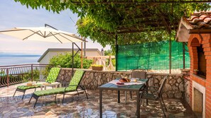 A patio with a table, chairs, and a view of the sea. - Apartment Milena 3 Opatija by Villas Guide (Liganj)