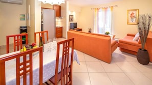 A compact living space with a dining area, kitchenette, and a sofa. - Villa Palace Clara Apartment 2 island Krk  by Vill (Malinska)
