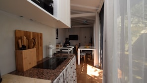 Una cucina moderna con un tagliere in legno, una macchina da caffè e un'area pranzo con tavolo e sedie.