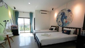 A hotel room with two beds, a balcony, a large seahorse artwork on the wall, and a small table with a vase.