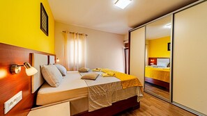 A hotel room with a bed, bedside lamp, and a mirror reflecting the room. - Villa Welcome by Villas Guide (Blato)