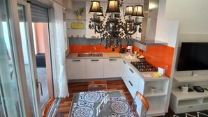 A modern kitchen with a chandelier, a dining table, and a TV. - PROMENADE Luxury View (Sarnico)