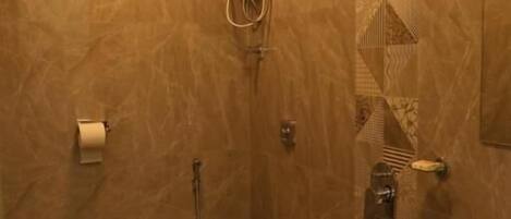 A bathroom with a toilet, bidet, sink, and a bucket.