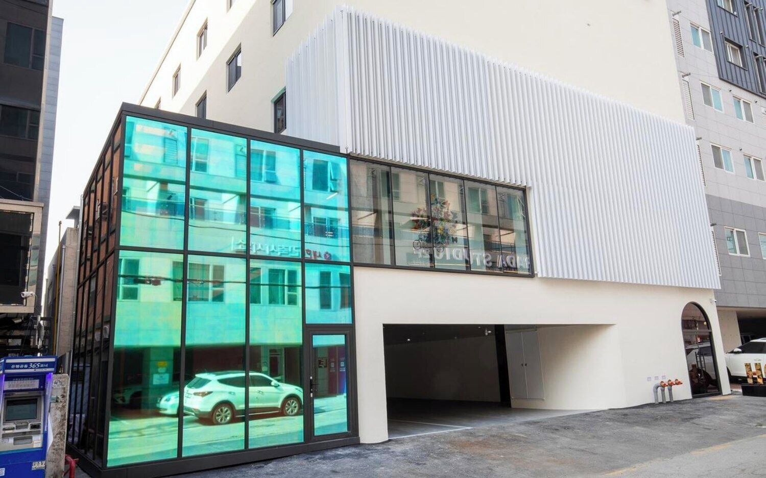 Un edificio moderno con fachada de vidrio y exterior blanco.