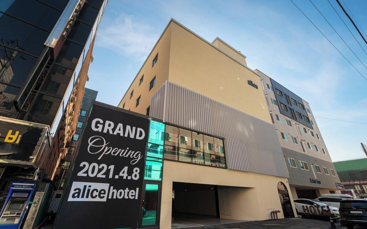A modern building with a sign indicating a grand opening on 2021.4.8 for the alice hotel.
