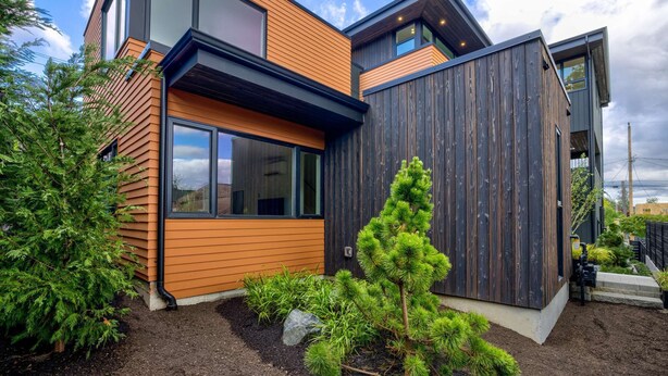 A modern two-story house with large windows, a wooden exterior, and a well-maintained garden. - Secret Hideaway - New Custom Built Home (Seattle)