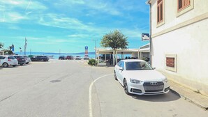 A parking lot with several cars, a white Audi parked on the side, and a building with a sign that reads "LAUTER".