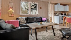 A cozy living room with a black leather sofa, a wooden table, and a hanging lamp. - "Iris" - 200m to the fjord by Interhome (Thyholm)