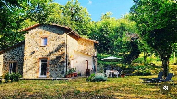 A stone house with a patio, outdoor seating, and a garden. - Detached house in the middle of the Tuscan chestnut forest (Arcidosso)