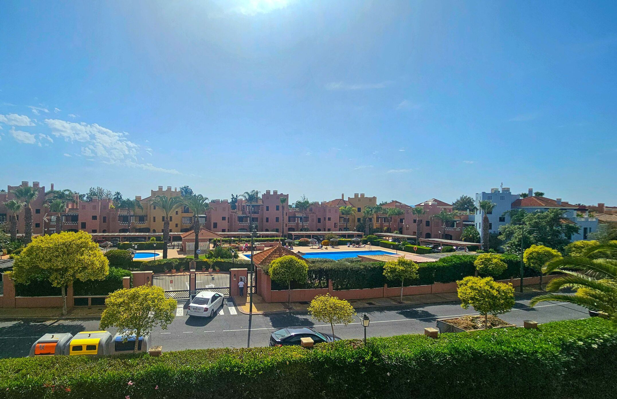 A residential area with multiple apartment buildings, a swimming pool, and a parking lot.