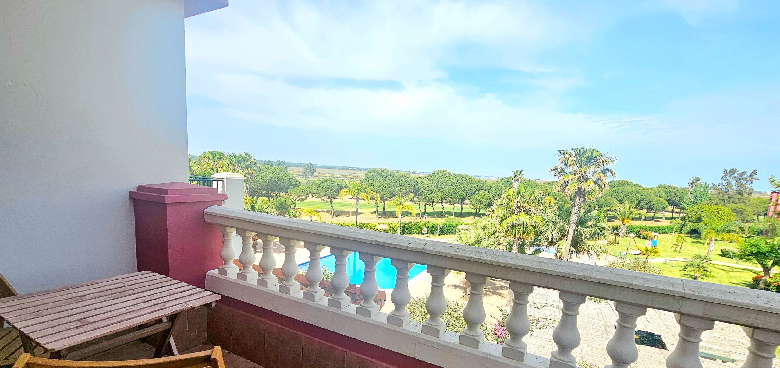 A balcony with a view of a landscaped garden.