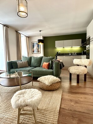 A modern living room with a sofa, a glass coffee table, a fluffy pouf, and a woven pouf. - Plein centre. Bel apt 4pièces de 80m2 pour 6 pers. (Cauterets)