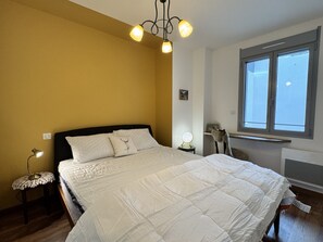 A bedroom with a bed, bedside lamps, a chair, a window, and a wall-mounted shelf. - Plein centre. Bel apt 4pièces de 80m2 pour 6 pers. (Cauterets)