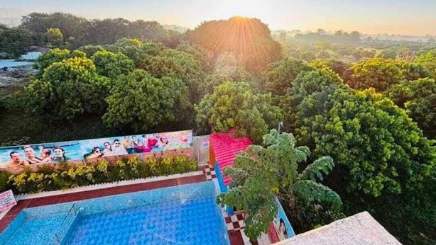 Un espace piscine offrant une vue sur un paysage boisé et une colline en arrière-plan.