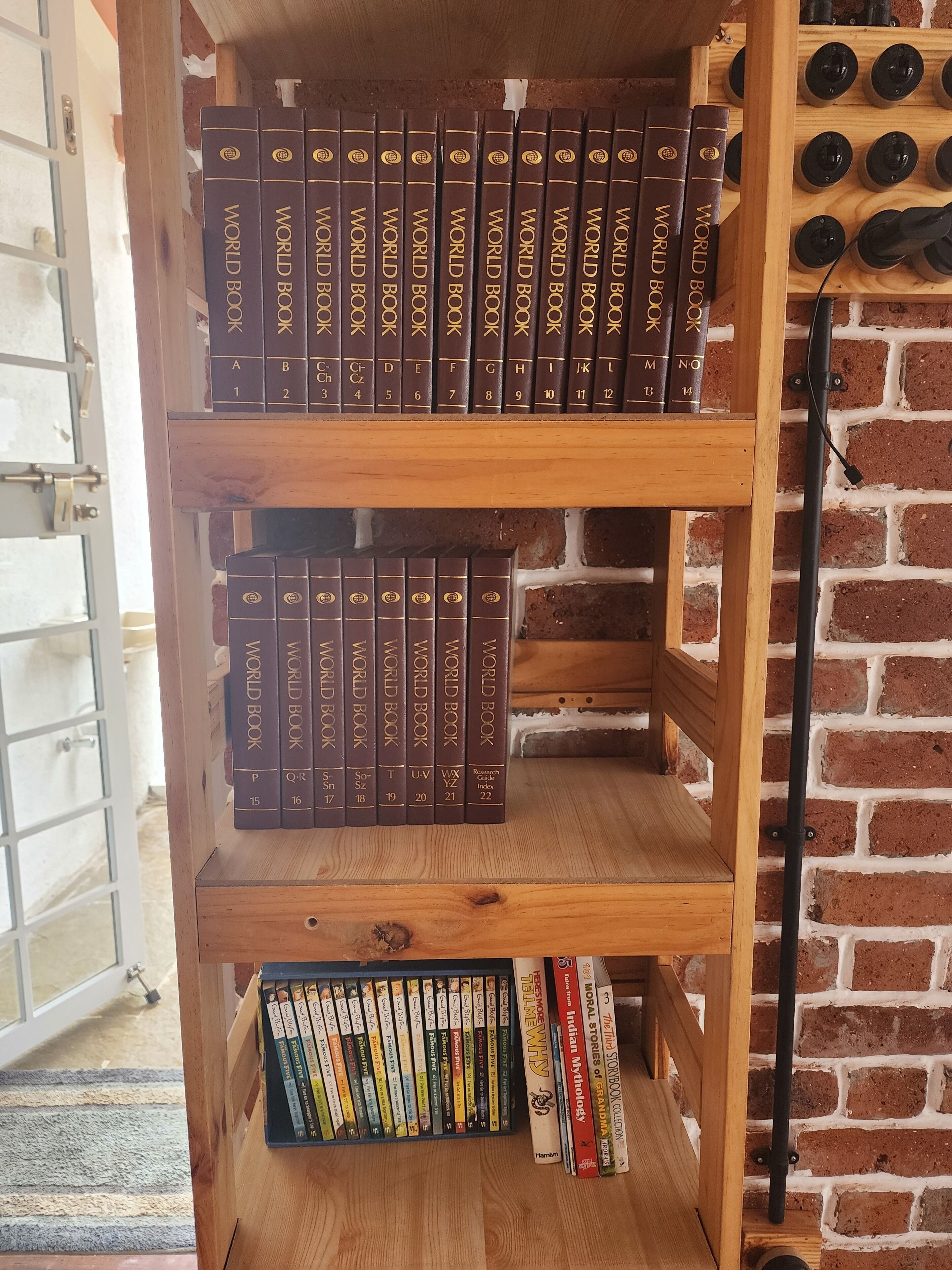 Una estantería de madera con varias repisas que contienen diferentes libros.