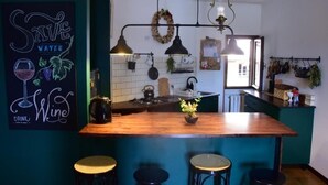 A kitchen with a wooden island, pendant lights, and a 'Save Water' poster.