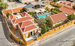 A residential area with multiple houses, a swimming pool, and a street. - Villa Grandi — three villas on one walled estate, for 16 guests in Otrobanda (Willemstad)