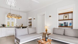 A modern living room with a sofa, a wooden coffee table, and a chandelier. - Villa Grandi — three villas on one walled estate, for 16 guests in Otrobanda (Willemstad)