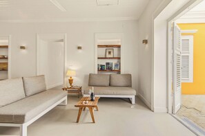 En moderne stue med sofa, sofabord og reol.