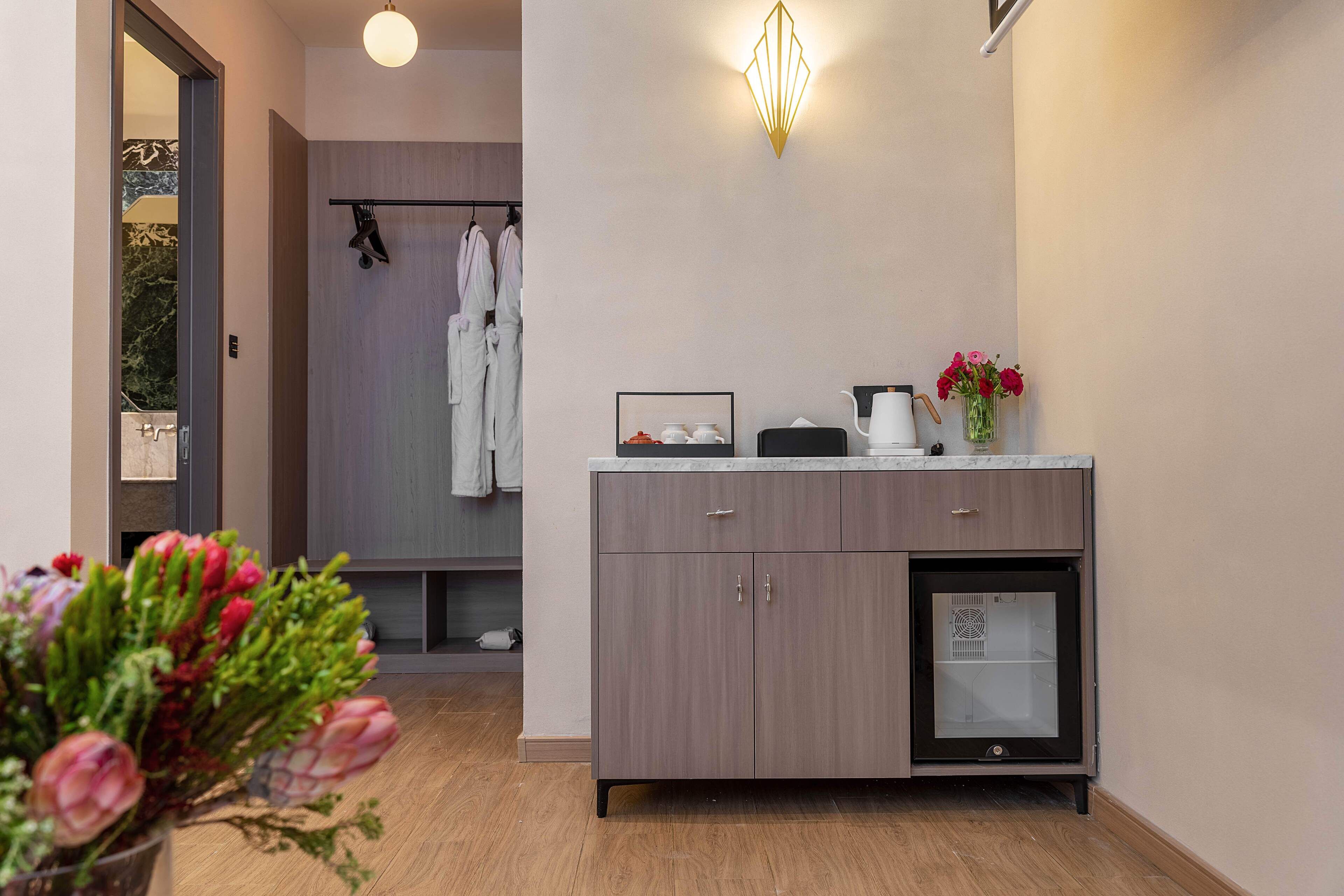 A modern bathroom with a wooden floor, a sink with a countertop, a mirror, and a shower area with a glass door.