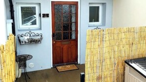A wooden door with a glass panel, a small window, and a wall-mounted shelf with items.