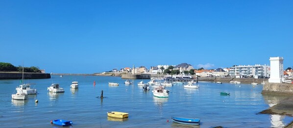 A harbor with boats, a lighthouse, and buildings along the shore. - Bed and Breakfast 'À 2 Pas Des Plages' with Shared Terrace, Shared Garden and Wi-Fi (Notre-Dame-de-Riez)