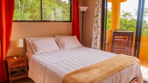 A bedroom with a bed, a nightstand, a lamp, and a view of the outdoors. - 4 Suites-Ocean view-Private pool (San Buenas)