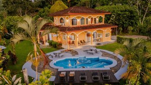 A two-story house with a swimming pool, surrounded by lush greenery. - 4 Suites-Ocean view-Private pool (San Buenas)