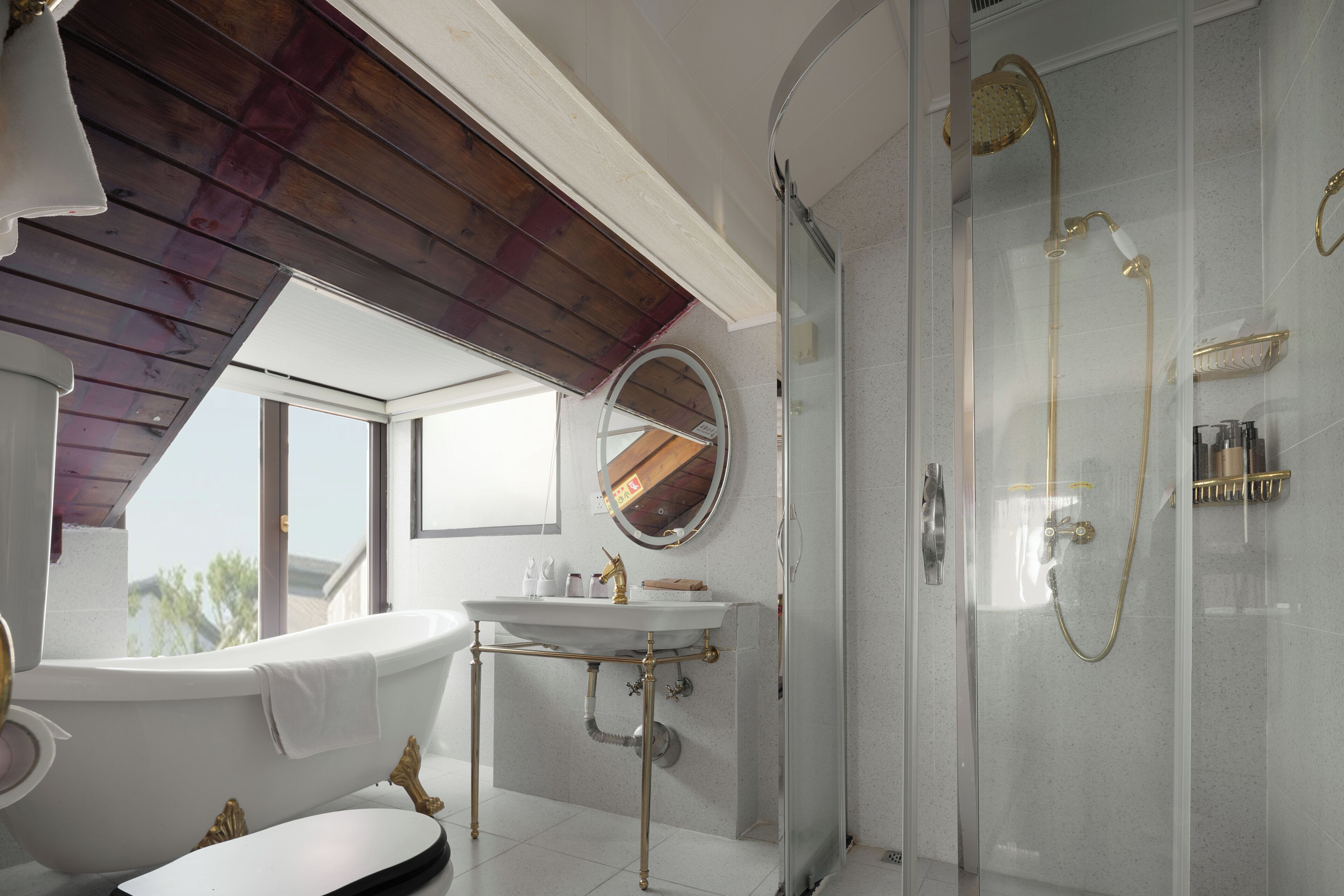 A bathroom with a bathtub, a sink, and a glass-enclosed shower.