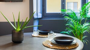 A dining table with a plant, two plates, and two glasses. - Design studio of wood & charm (Milano)