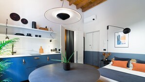 A modern kitchen with blue cabinets, a round table, and a potted plant. - Design studio of wood & charm (Milano)