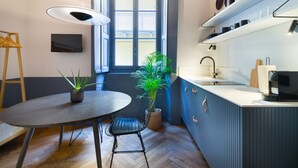 A compact kitchen with a dining area, a potted plant, and a window with a view. - Design studio of wood & charm (Milano)