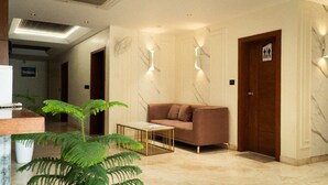 Eine Lobby mit einer Couch, einem Couchtisch und einer Rezeption.
