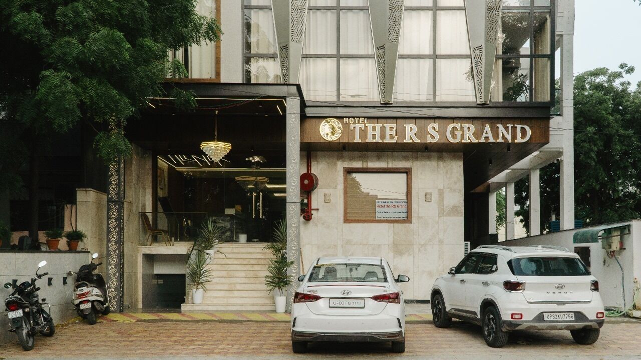 A hotel entrance with a sign reading "THE R'S GRAND".