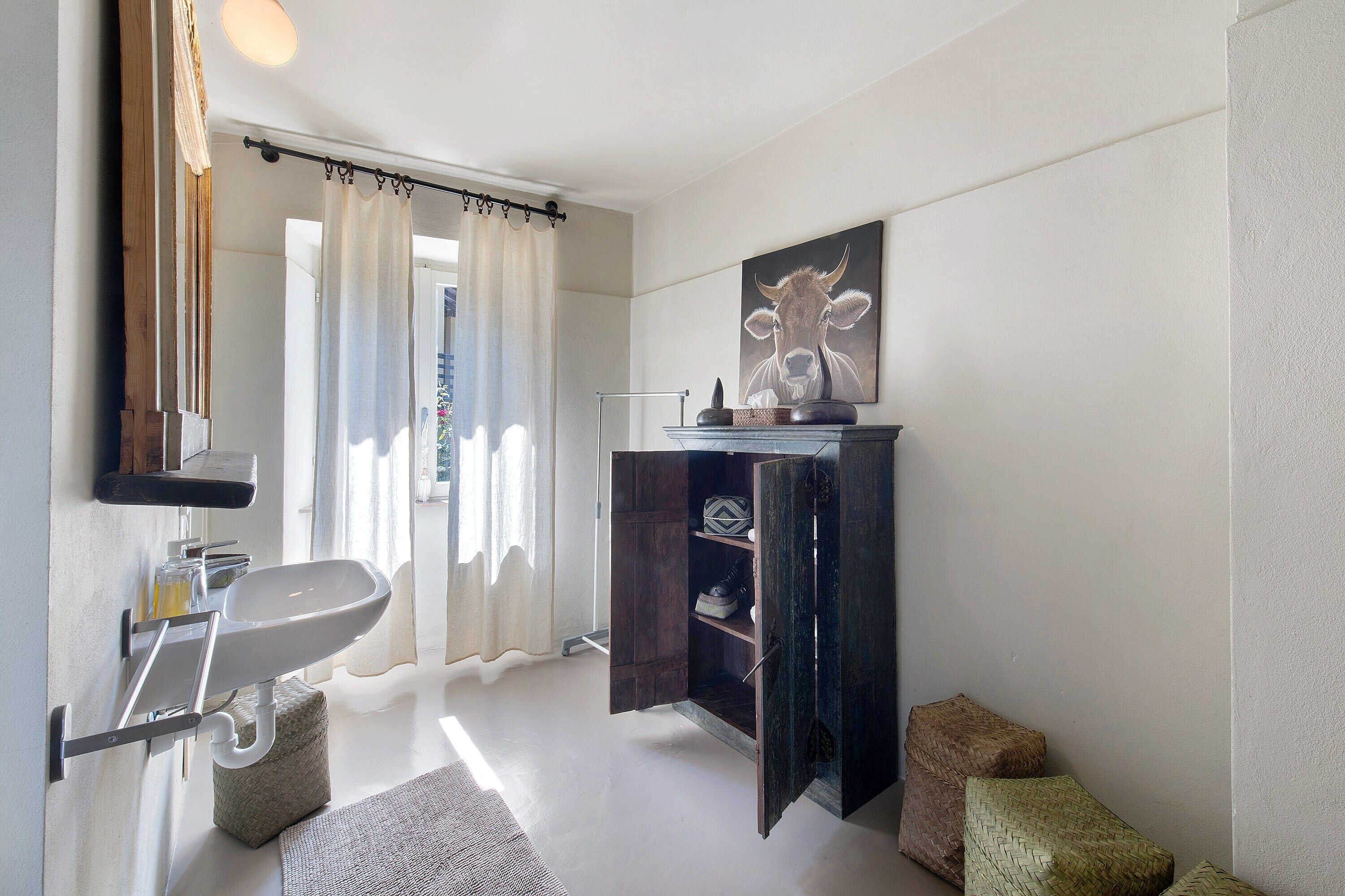 Un baño con lavamanos, espejo y cortina de ducha.