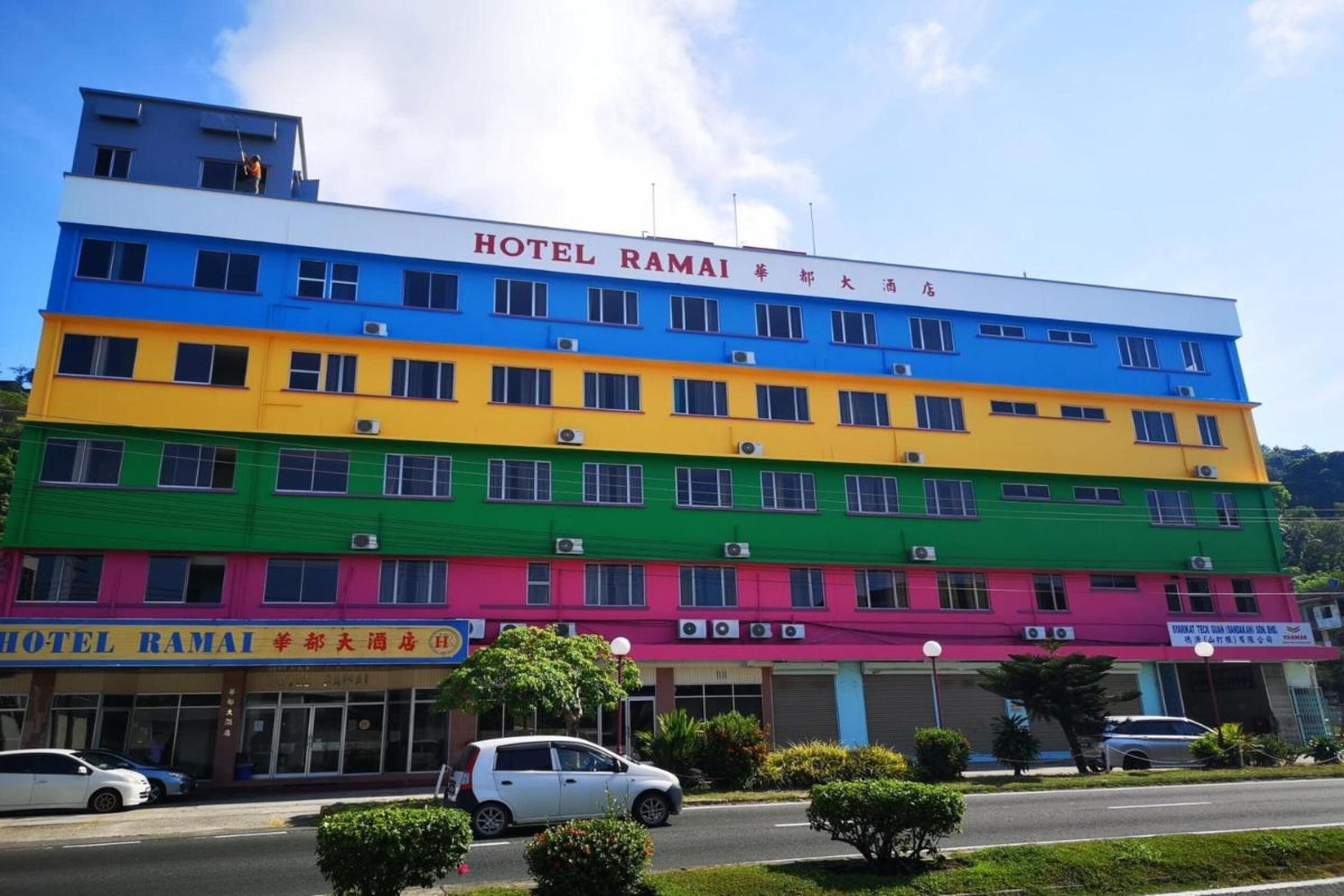 A multi-story hotel with a colorful facade, featuring a prominent sign at the top.