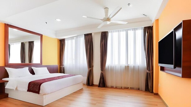 A hotel room with a large bed, a ceiling fan, a flat-screen TV, and a large window with curtains. - Hotel O Ramai (Sandakan)