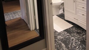 A bathroom with a toilet, sink, and mirror. There is a sign on the wall that says "Live Laugh Love." - Turnagain inn  (Anchorage)